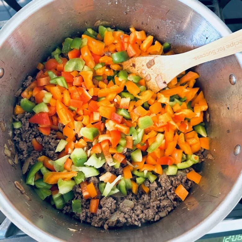 Peppers added to a pot with ingredients to make stuffed pepper soup.