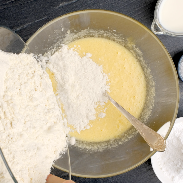 Dry ingredients being added to wet ingredients to make banana cake with cream cheese frosting.