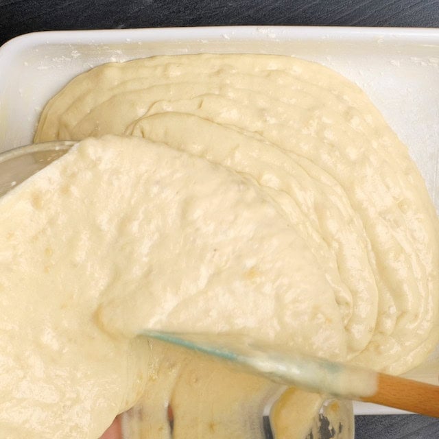 Banana cake batter being poured into a baking pan.
