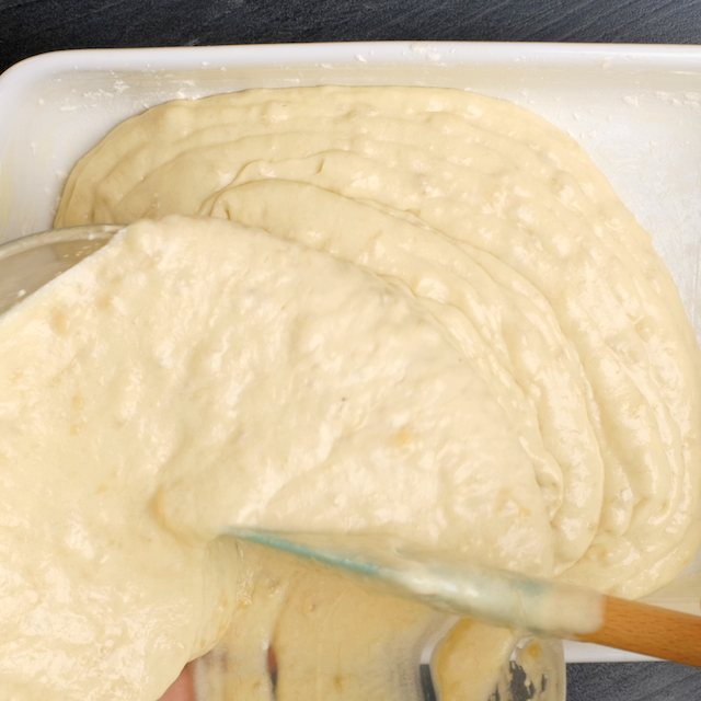Banana cake batter being poured into a baking pan.