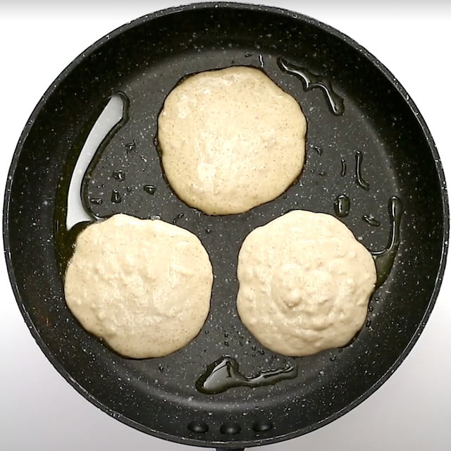 Coconut pancake batter poured into a greased pan to make pancakes at home.