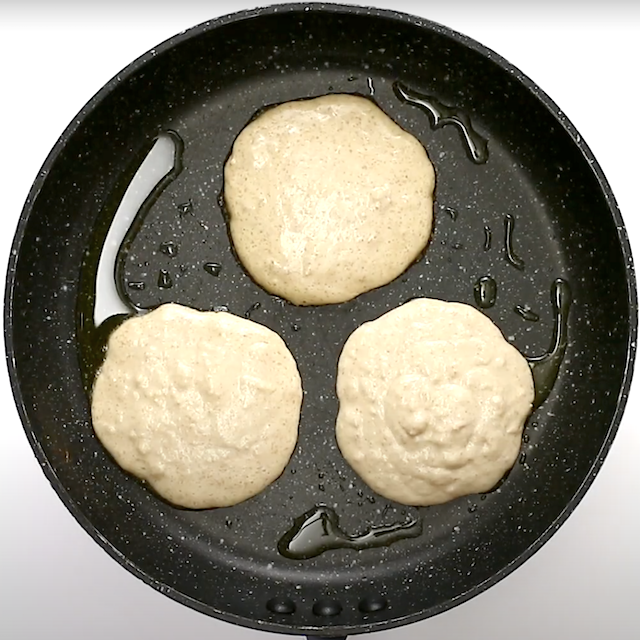 Coconut pancake batter poured into a greased pan to make pancakes at home.