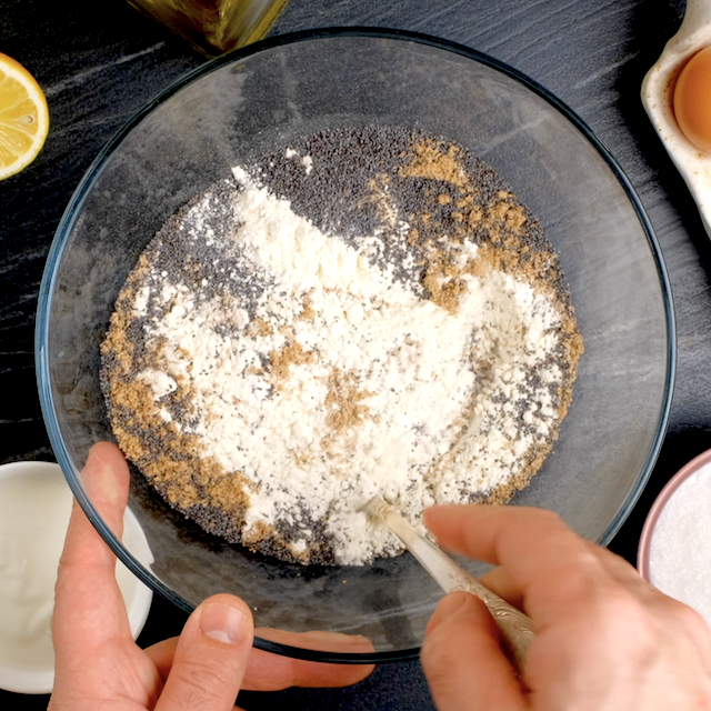 Dry ingredient to make lemon poppy seed bread being mixed in a glass bowl.