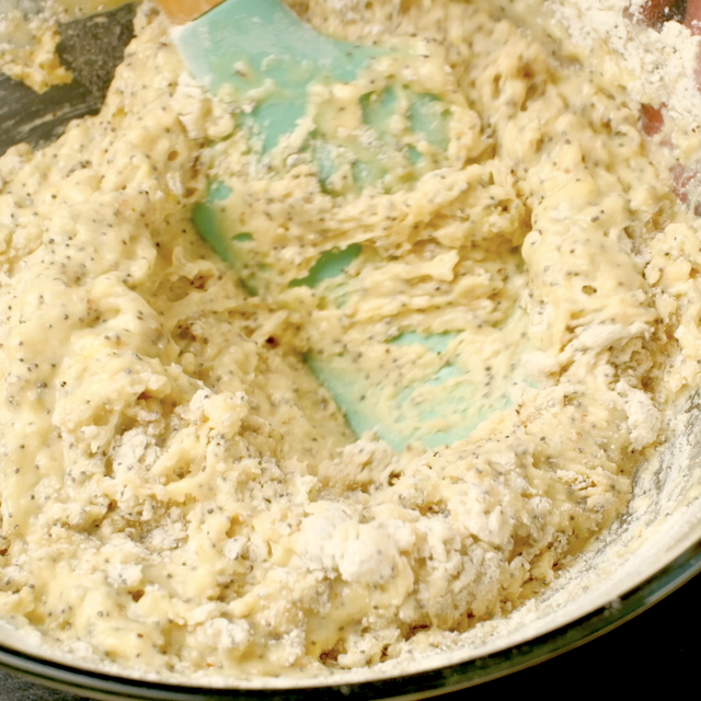 Dry and wet ingredients to make lemon poppy seed bread being folded together.