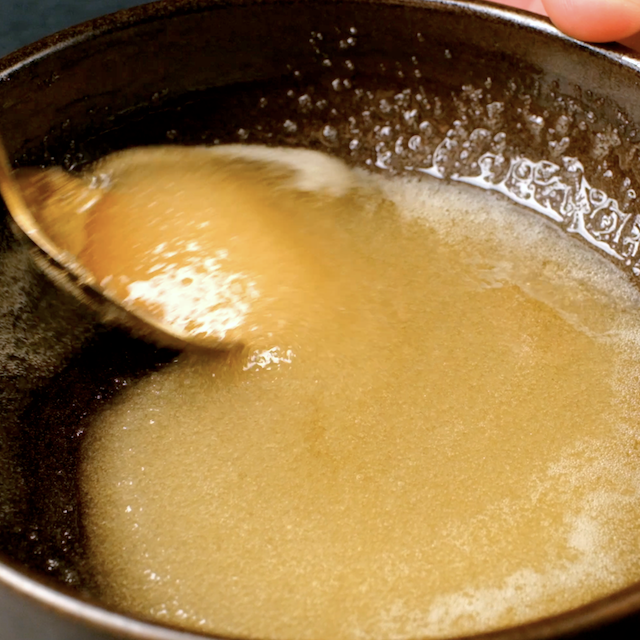 Ingredients to make glaze for lemon poppy seed bread being mixed in a bowl.
