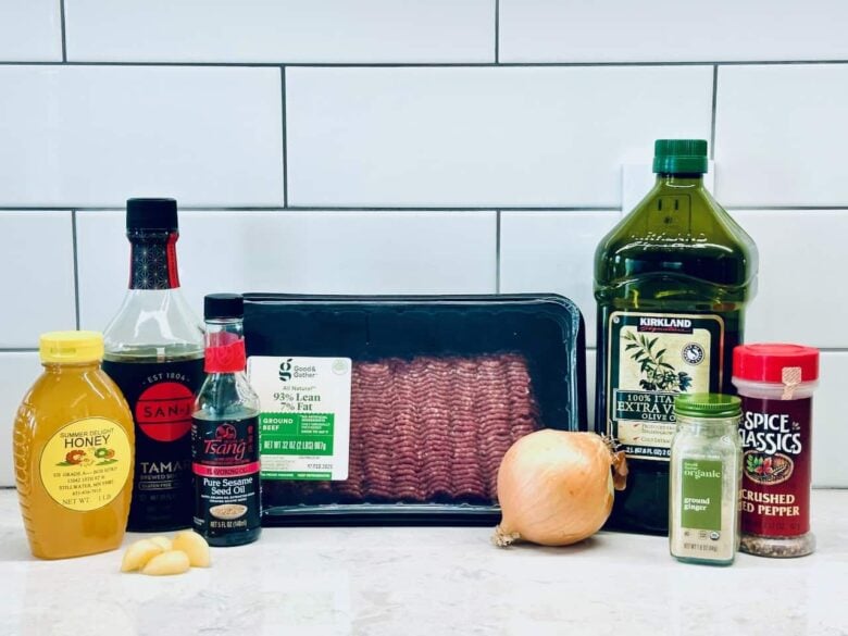 Ingredientai, skirti korėjiečių jautienos dubenėlio receptui ant balto virtuvės prekystalio.
