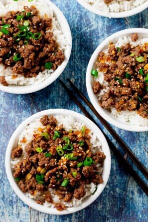 Overhead shot of Korean beef bowls garnished with sliced green onions.