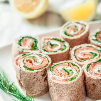 A plate full of smoked salmon pinwheels, ready to be served.