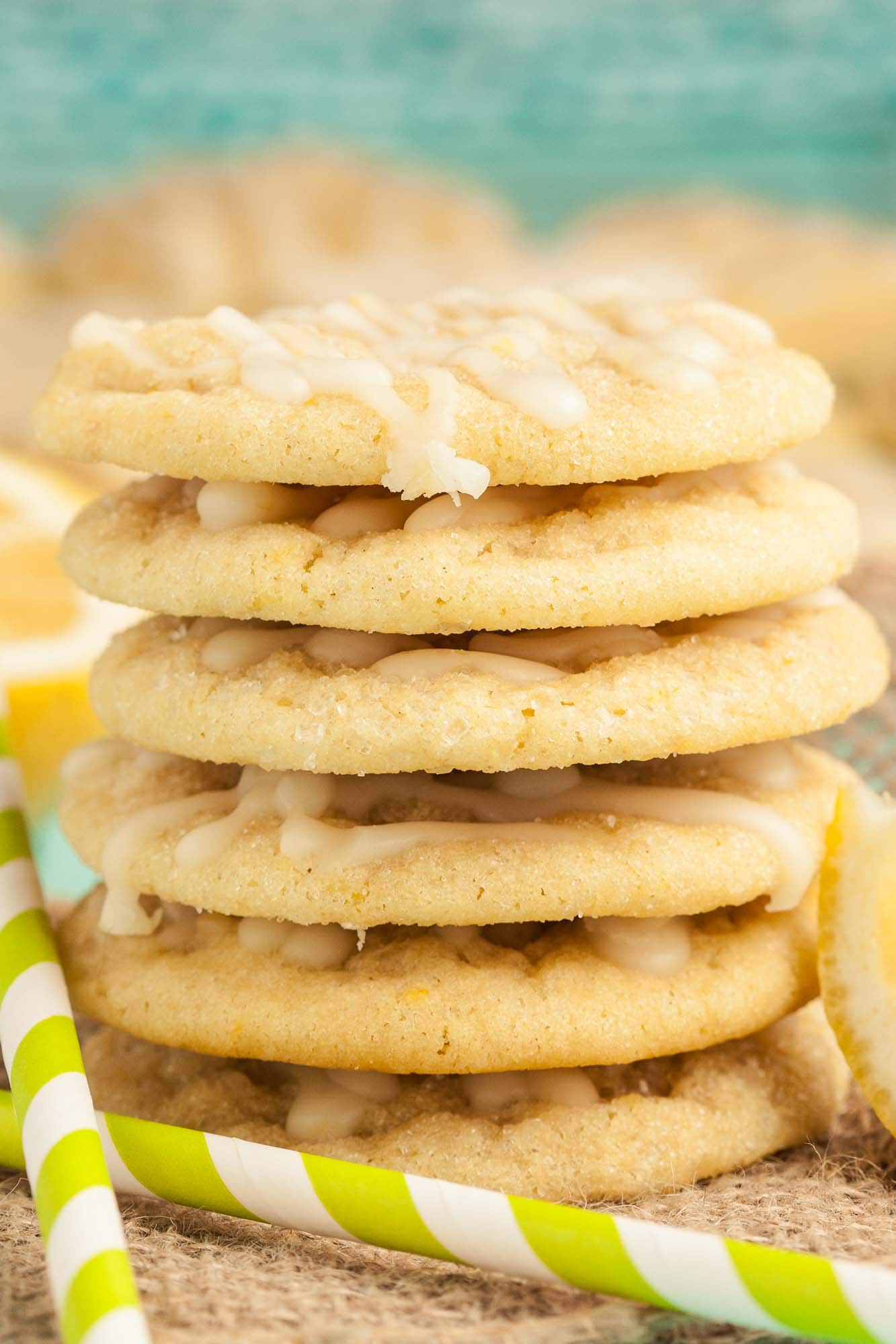 A stack of soft lemon cookies with lemon icing, sitting on a burlap cloth.