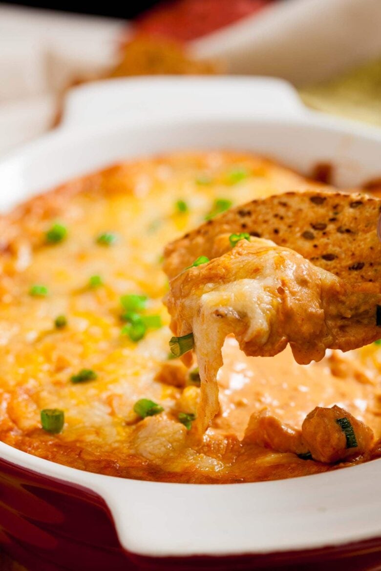 Closeup shot of a cracker with creamy, cheesy mexican bean dip.