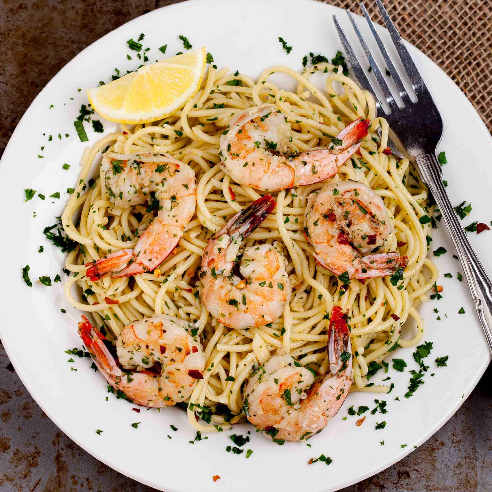 Overhead shot of a plate with lemon pepper shrimp over a bed of buttery pasta.