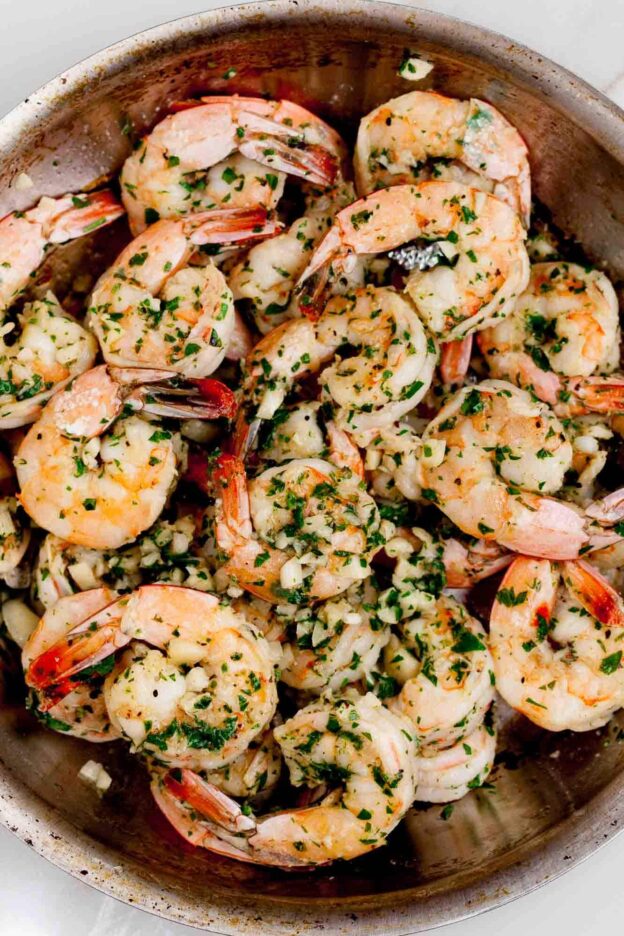 Overhead shot of a pan with Lemon Pepper Shrimp, garnished with chopped parsley.