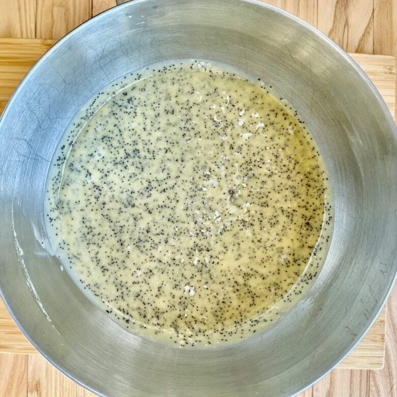 Wet ingredients being whisked together to make poppy seed cake.