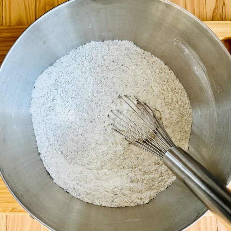 Dry ingredients being whisked together to make poppy seed cake.