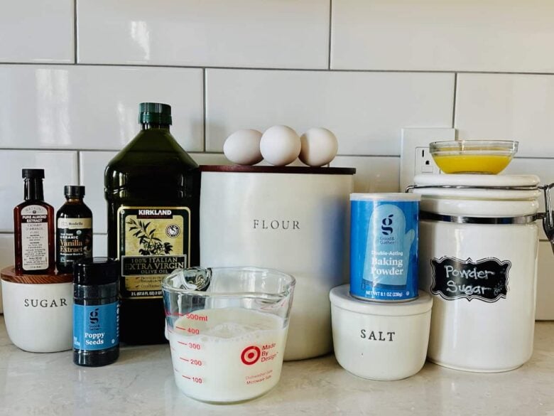 Ingredients to make poppy seed cake on a white kitchen counter.