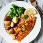 Overhead shot of crispy air fryer tilapia with roasted potatoes and broccoli.