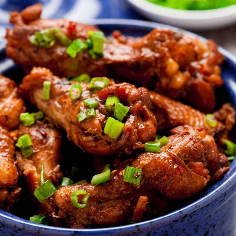 Closeup shot of Asian Chicken Wings in a blue serving bowl.