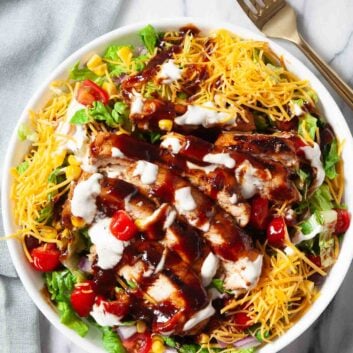 Overhead shot of BBQ chicken saald with bbq sauce and shredded cheese on top.