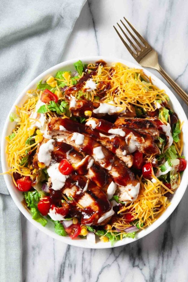 Overhead shot of BBQ chicken saald with bbq sauce and shredded cheese on top.