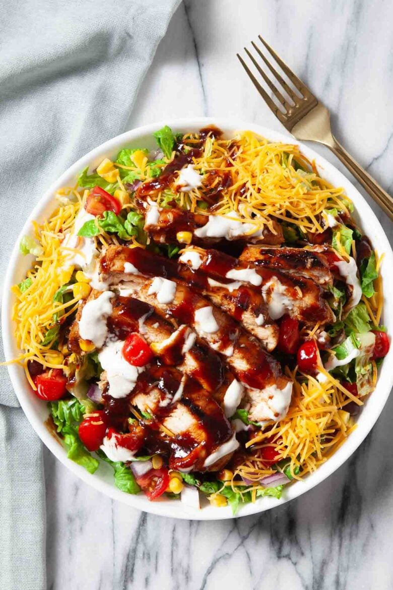 Overhead shot of BBQ chicken saald with bbq sauce and shredded cheese on top.
