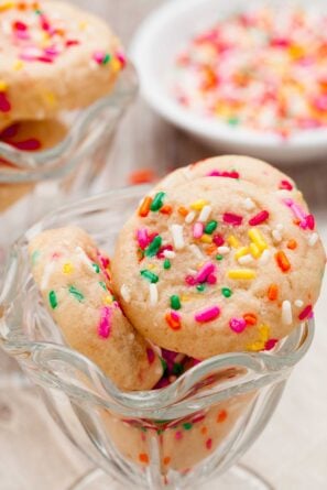 Closeup shot of funfetti cookies with colorful sprinkles in a glass bowl.