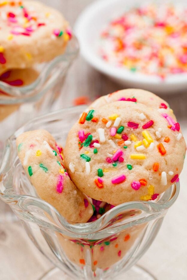 Closeup shot of funfetti cookies with colorful sprinkles in a glass bowl.