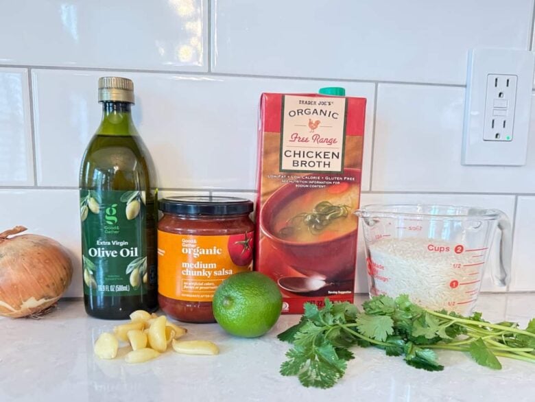 Ingredients to make instant pot Mexican rice on a white kitchen counter.