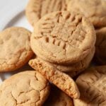 Freshly made chewy peanut butter cookies with crisscross pattern on top.