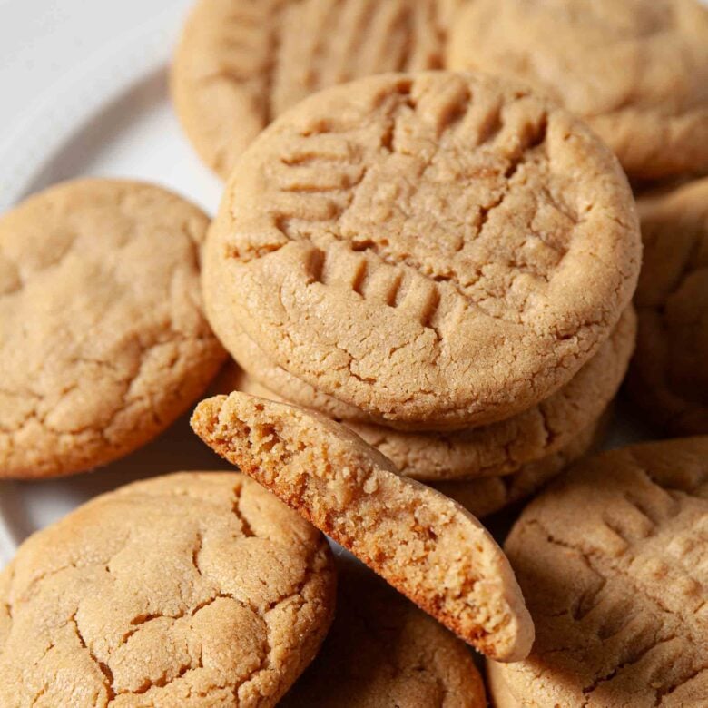 Freshly made chewy peanut butter cookies with crisscross pattern on top.
