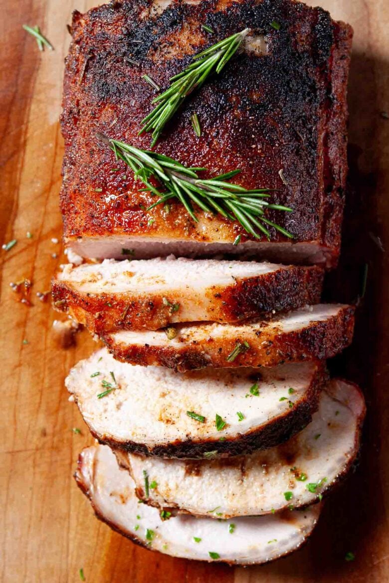 Overhead shot of sliced smoked pork loin on a chopping board.