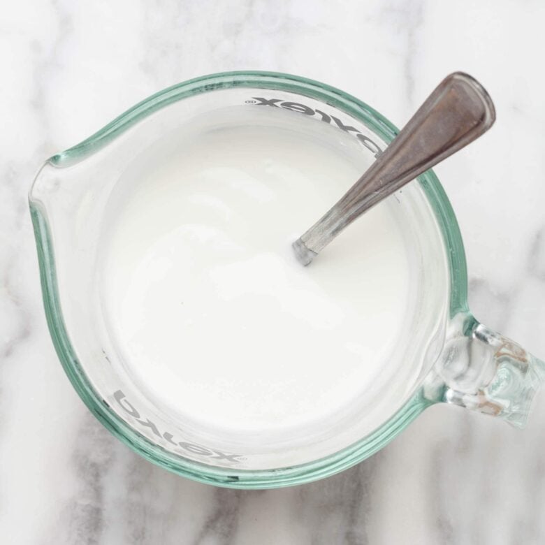 Overhead shot of plain whole yogurt to make spinach artichoke dip without mayo at home.