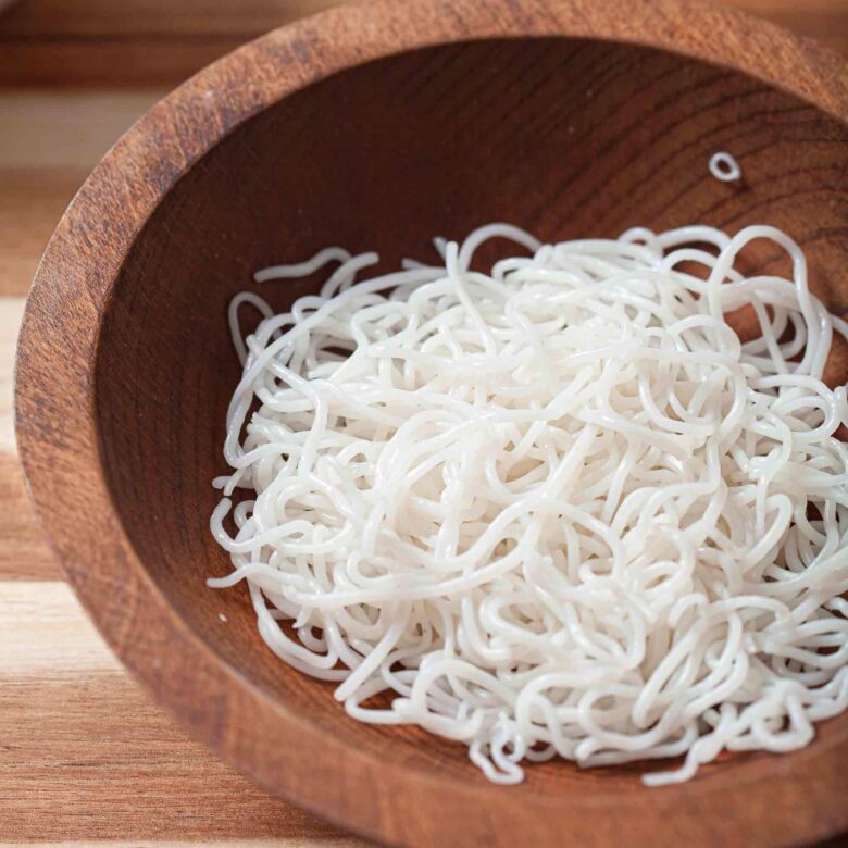 Rice vermicelli in a wooden bowl to make vietnamese spring rolls with dipping sauce.