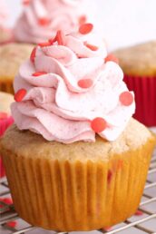 Closeup shot of strawberry cupcake with whipped cream frosting.