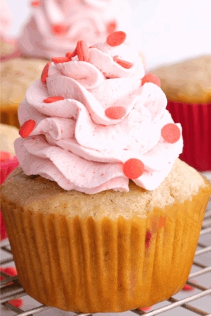 Closeup shot of strawberry cupcake with whipped cream frosting.