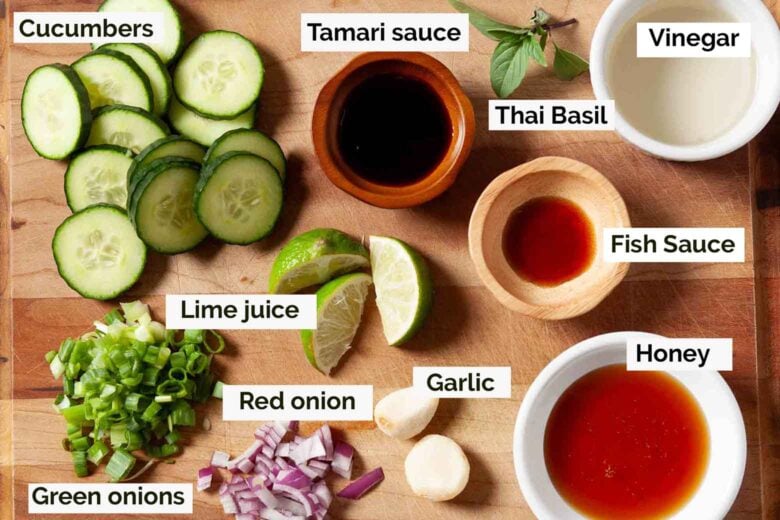 Asian cucumber salad ingredients such as fish sauce, honey, garlic, lime juice, red onion, garlic, tamari sauce, thai basil, and vinegar.