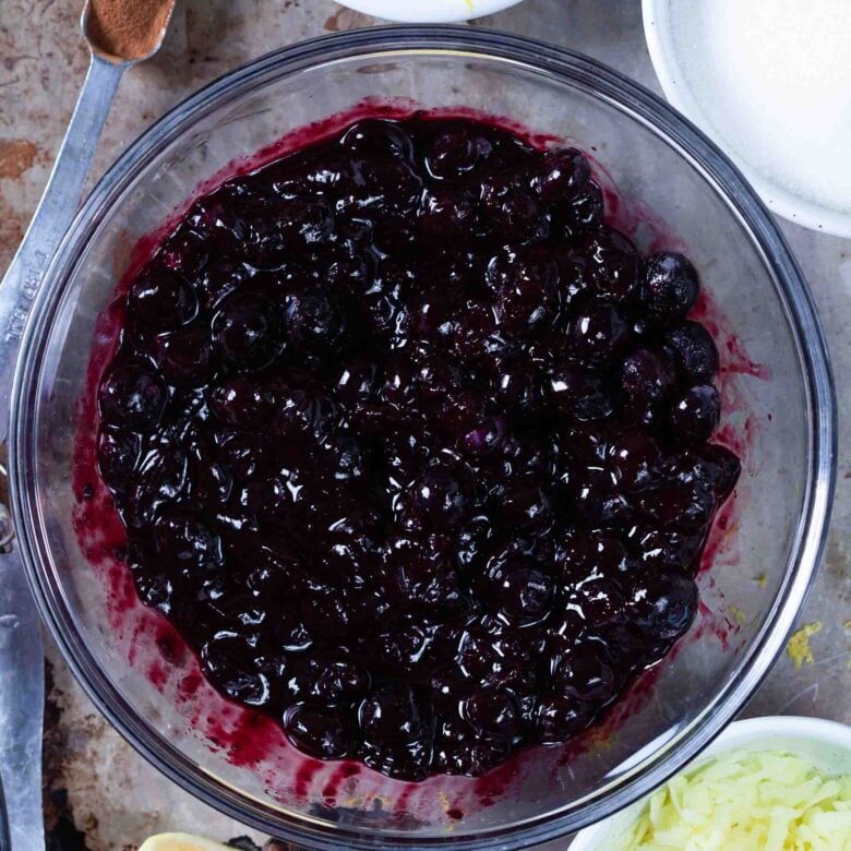 Freshly made blueberry pie filling recipe in a glass mixing bowl.