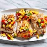 Three pieces of seared Mahi Mahi are topped with a vibrant mango salsa.