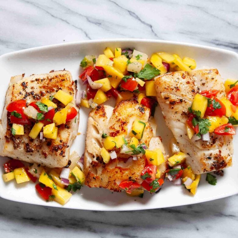 Three pieces of seared Mahi Mahi are topped with a vibrant mango salsa.