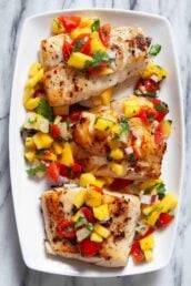 Three pieces of seared Mahi Mahi are topped with a vibrant mango salsa.