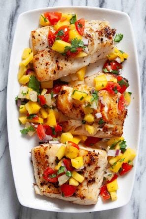 Three pieces of seared Mahi Mahi are topped with a vibrant mango salsa.