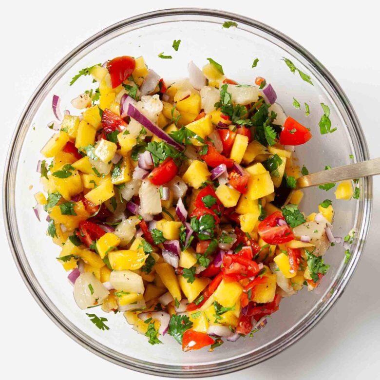 Overhead shot of mango salsa in a glass bowl.