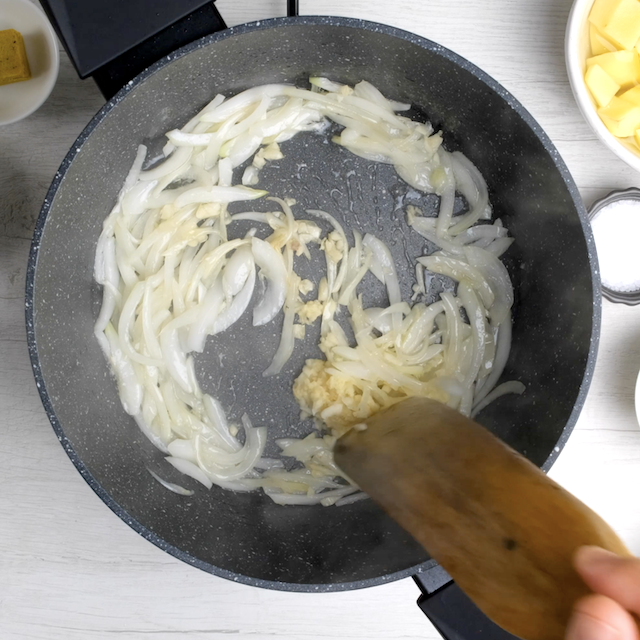 Onion and garlic being sautéed in a pan to make Japanese chicken curry.