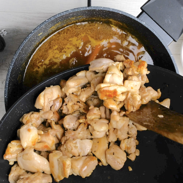 Cooked chicken being added to homemade curry to make Japanese chicken curry at home.