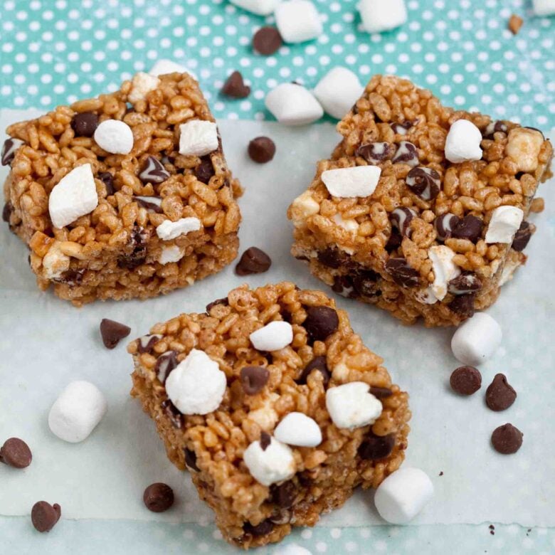 Overhead shot of three peanut butter rice krispie treats squares with chocolate chips and mini marshmallows.