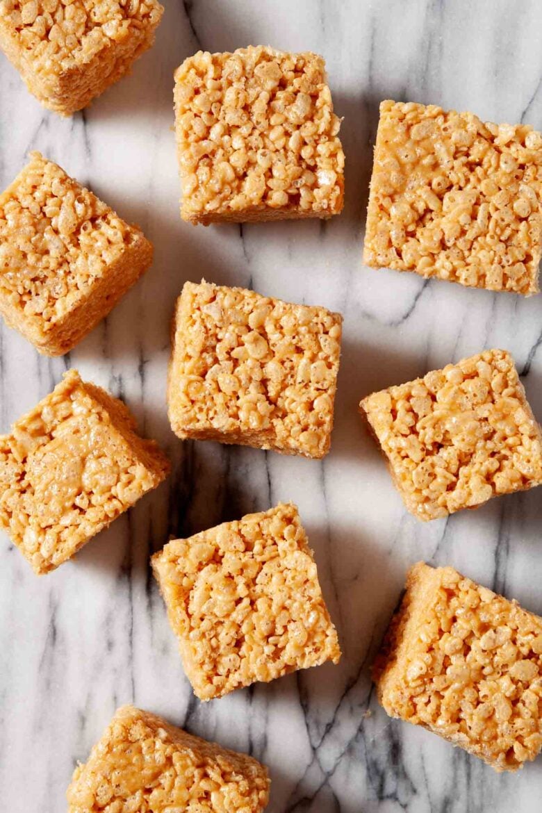 Overhead shot of homemade healthy rice krispie treat squares on a marbled surface.
