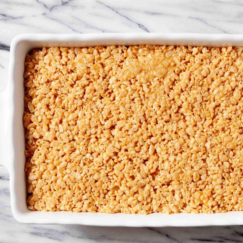 Healthy rice krispie treat mixture pressed into a greased pan.