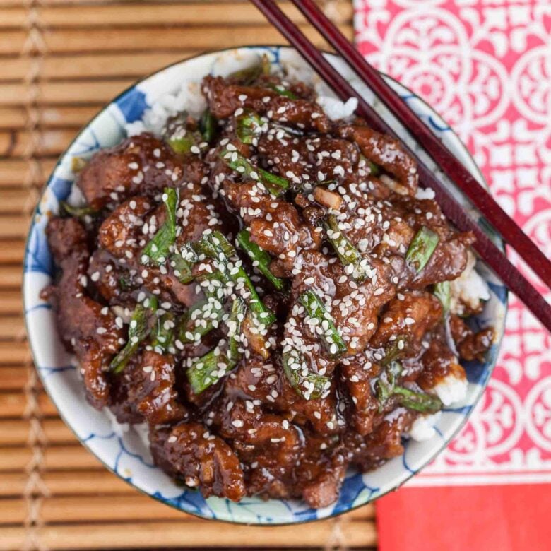 Overhead shot of a bowl with homemade Mongolian beef recipe with sesame seeds on top.