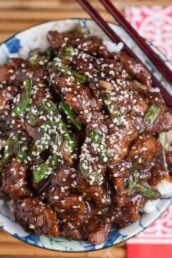 Overhead shot of a bowl with homemade Mongolian beef recipe with sesame seeds on top.