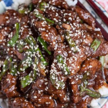 Overhead shot of a bowl with homemade Mongolian beef recipe with sesame seeds on top.