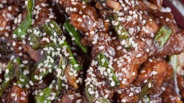 Overhead shot of a bowl with homemade Mongolian beef recipe with sesame seeds on top.